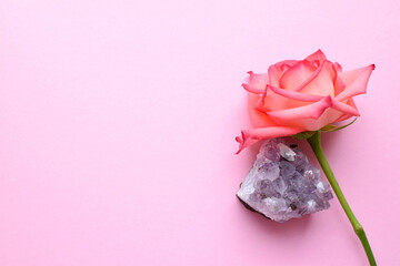 Druse amethyst and one rose on a pink background. Copy space for text