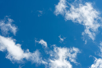A clear blue sky with white clouds