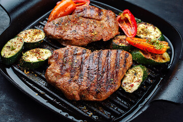 Traditionelles Barbecue Halsgrat vom Schwein mit gegrilltem Gemüse und Gewürzen serviert als Draufsicht in einer rustikalen Design Pfanne