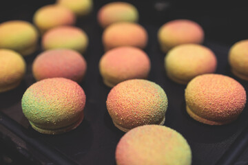 Beautiful multicolored decorated baked sweet tasty candy bar dessert on kids children party with happy people around, catering banquet table on a kids children party