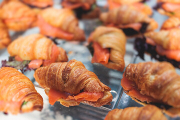 Decorated catering banquet table with variety of different pastry and bakery, with croissants on corporate party event in the hotel during conference meeting, set of coffee break