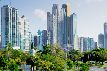 Obraz premium monument to vasco nunes de balboa between trees and skyscrapers in the background on avenida balboa city of panama panama