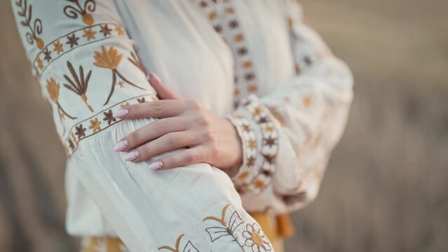 Ukrainian woman showing embroidery ornament, beautiful details of vyshyvanka shirt. National costume - embroidered shirt, texture, design, folk, handmade craft needlework