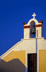 A little bell tower in Santorini, Thera, against the blue sky