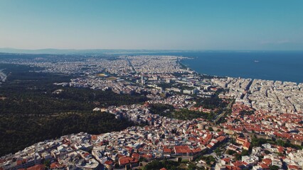 Fototapeta premium Greek city seen from aerial drone perspective. Typical Greek orange rooftops and whitewashed walls. Seashore. High quality photo