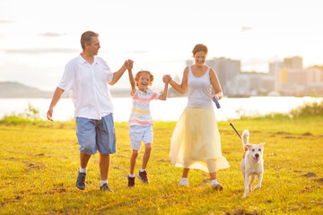 Fototapeta premium Family with kids running outdoor at sunset.
