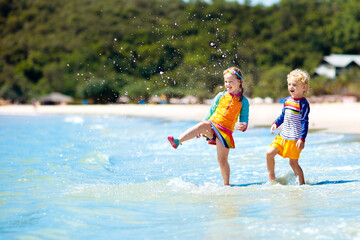 Kids on tropical beach. Children playing at sea.