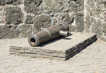 Muzzle of an old cannon. Artillery weapons of the Middle Ages. Foundry business. Monument to weapons.