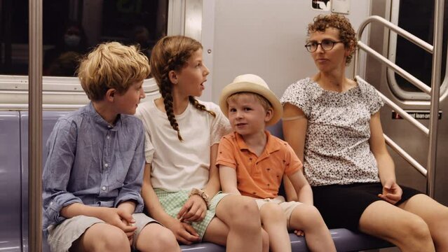 Mom with 3 Kids Ride Subway. They Sit Inside Metro Coach and Talk to Each Other
