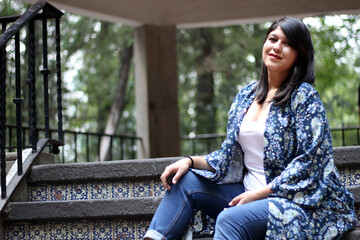 Latin adult woman sitting in a park enjoying the outdoors in relaxation and tranquility
