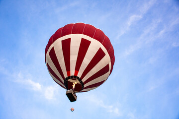 Fototapeta premium Striped hot air balloon flying in the sky 