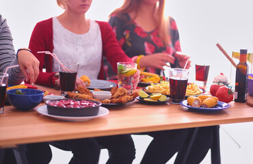 Top view of group of people having dinner together while sitting at wooden table. Food on the table. People eat fast food.