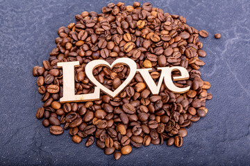 Close-up of coffee beans in the shape of a heart and the inscription love