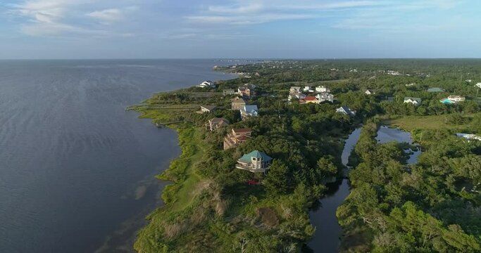 Drone shot of homes along the Pamlico Sound in the Outer banks near Frisco, NC with Hatteras in the background