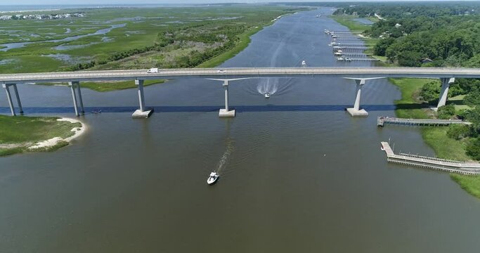 Drone shot of boat going under Sunset Beach Bridge on the Intercoastal Waterway in North Carolina near Myrtle Beach