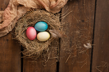 Painted Easter chicken eggs in a nest. Holiday Easter concept background. High quality photo