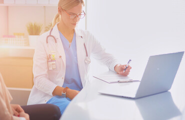 Doctor and patient couple are discussing something,sitting on the desk.