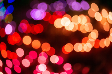 Dancing holiday bokeh lights glowing in deep jewel tones overlap in a colorful design pattern