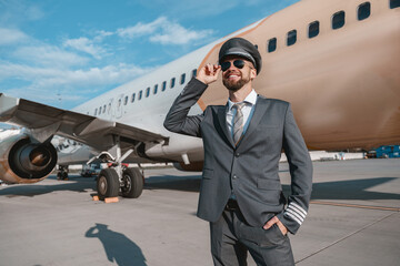 Cheerful aircraft pilot standing outdoors at airport