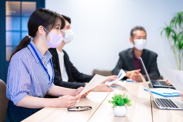 Businesspersons in a meeting wearing a mask