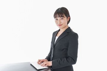 立ってデスクワークをする若いビジネスウーマン