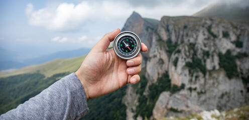 A male is looking for a compass in the mountains