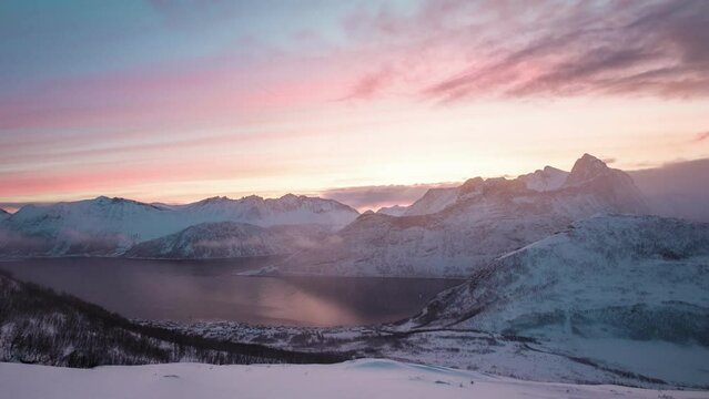 Sunrise over snowy mountain peak in blizzard on Segla mount in the morning at Senja island, Norway