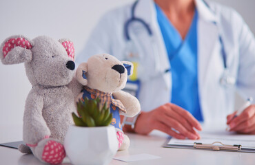 Beautiful young smiling female doctor sitting at the desk.