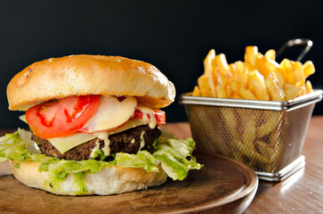 the photograph shows a delicious hamburger accompanied by french fries