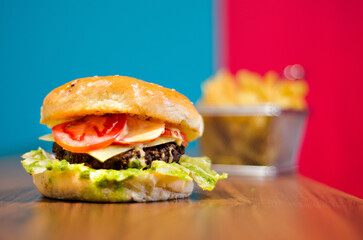 the photograph shows a delicious hamburger accompanied by french fries