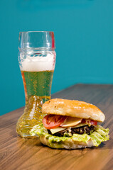 the photograph shows a delicious hamburger accompanied by a beer