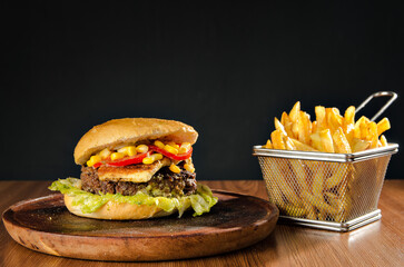 the photograph shows a delicious hamburger accompanied by french fries