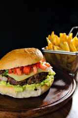 the photograph shows a delicious hamburger accompanied by french fries