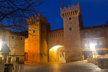 Night view of monumental gate Puerta Baja on main city street of Daroca, Zaragoza, Spain