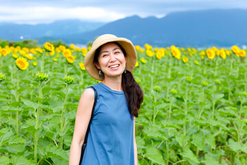 ひまわり畑と麦わら帽子の女性