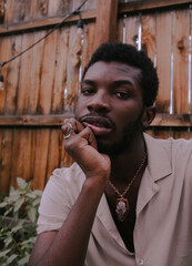 Black man looking at the camera with hand on face