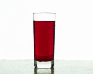 tall glass with iced hibiscus water, on a white background, hibiscus flower infusion, tea (jamaica)