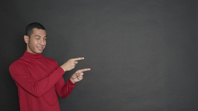 Expressive Young Man Presenting To His Side On A Black Background