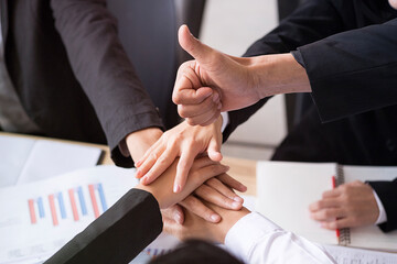 Close-up of business partners.  At Meeting they’re making pile of hands.