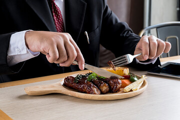 Businessmen are eating steak in a restaurant.