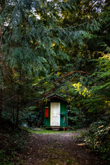 Fototapeta na wymiar Small green outhouse in the woods