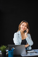 Young asian businesswoman beautiful charming smiling and talking on the mobile phone in the office.
