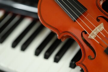 violin placed on a piano on a black background