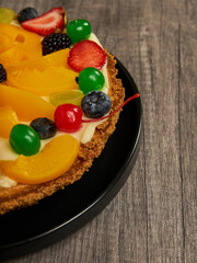 fruitcake with strawberries, blueberries, cherries and peaches close-up view