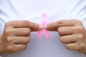 holding a pink ribbon breast cancer awareness concept