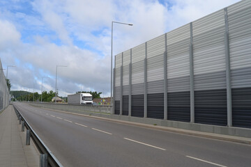 A noise barrier (also called a soundwall, noise wall, sound berm, sound barrier, or acoustical...