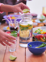 Top view of group of people having dinner together while sitting at wooden table. Food on the table. People eat fast food.