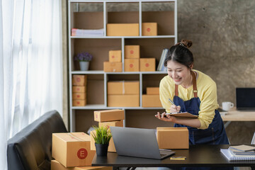 Small Business Startup SME Owners Asian Women Also Check Online Orders Laptops and sales of work items with girl boxes. Work independently at home, online SME business, small and medium enterprises