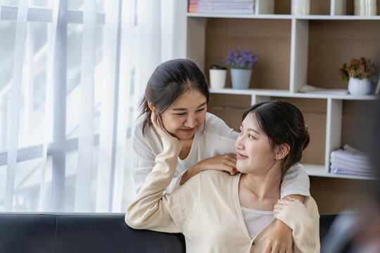 Concept of LGBT, homosexuality, portrait of two Asian women posing happily together and loving each other while playing together on the sofa.
