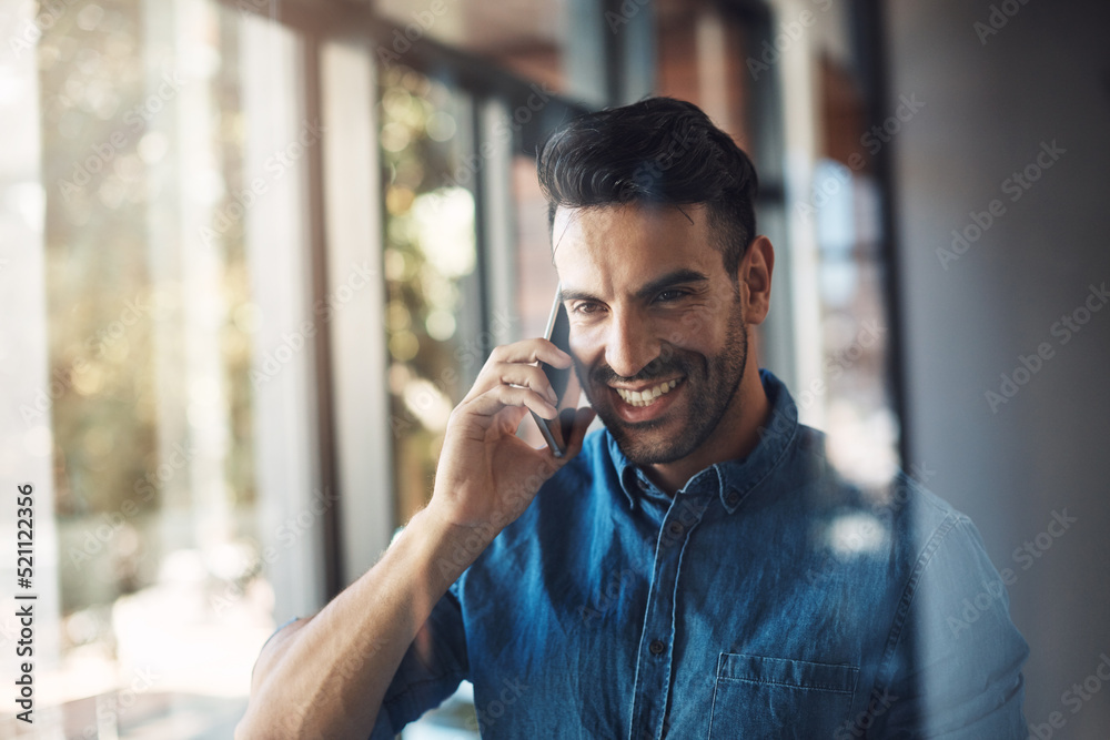 Wall mural Business man talking on phone while looking happy, smiling and cheerful in a modern office at work. One young male corporate professional making conversation, networking and discussing on a call